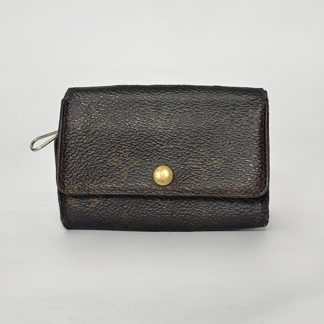 Black leather wallet with a gold button on a light gray background