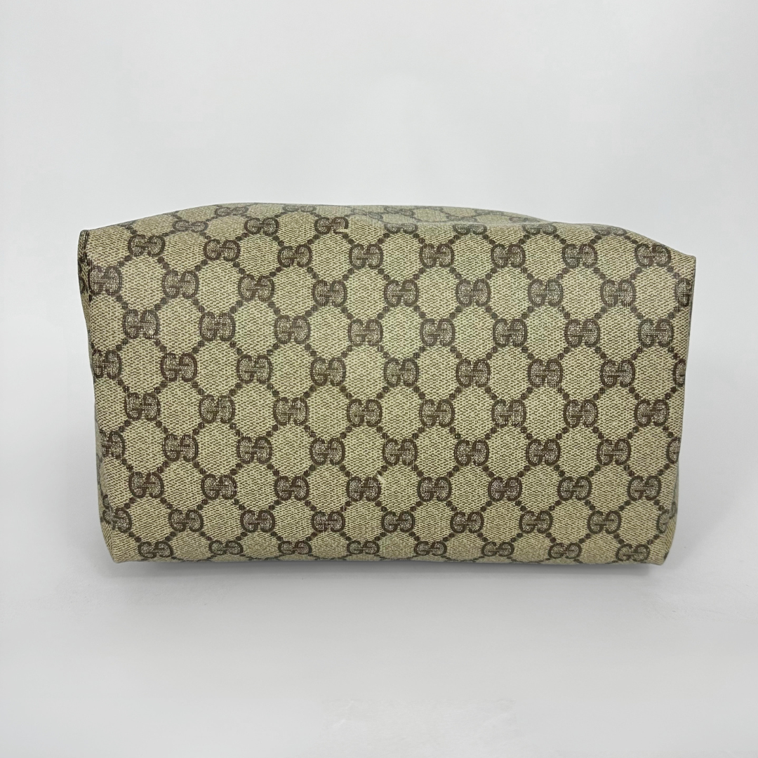 Designer tote bag with monogram pattern and red and green stripes on a light gray background