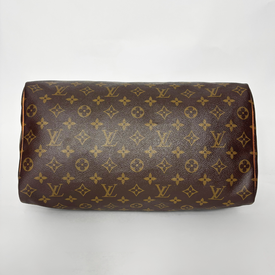 Brown handbag with monogram pattern on a white background