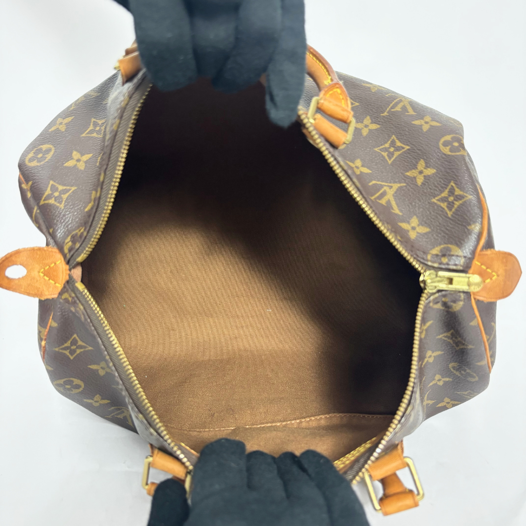 Brown handbag with monogram pattern on a white background