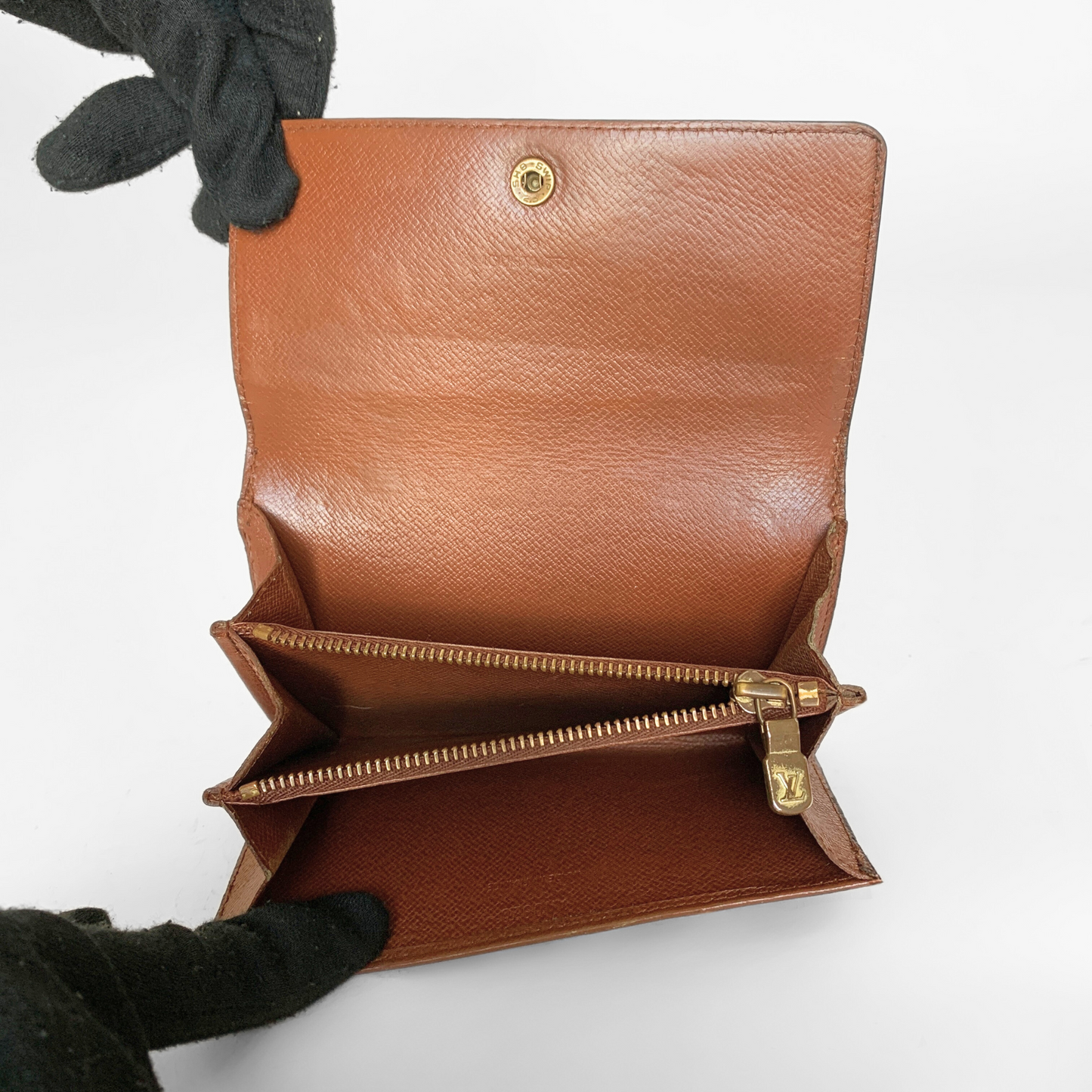 Black leather wallet with a gold button on a white background