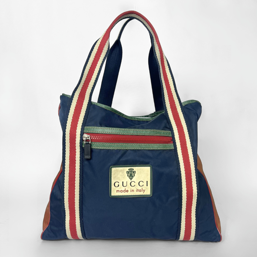 Navy blue tote bag with red and white stripes and Gucci logo on a white background