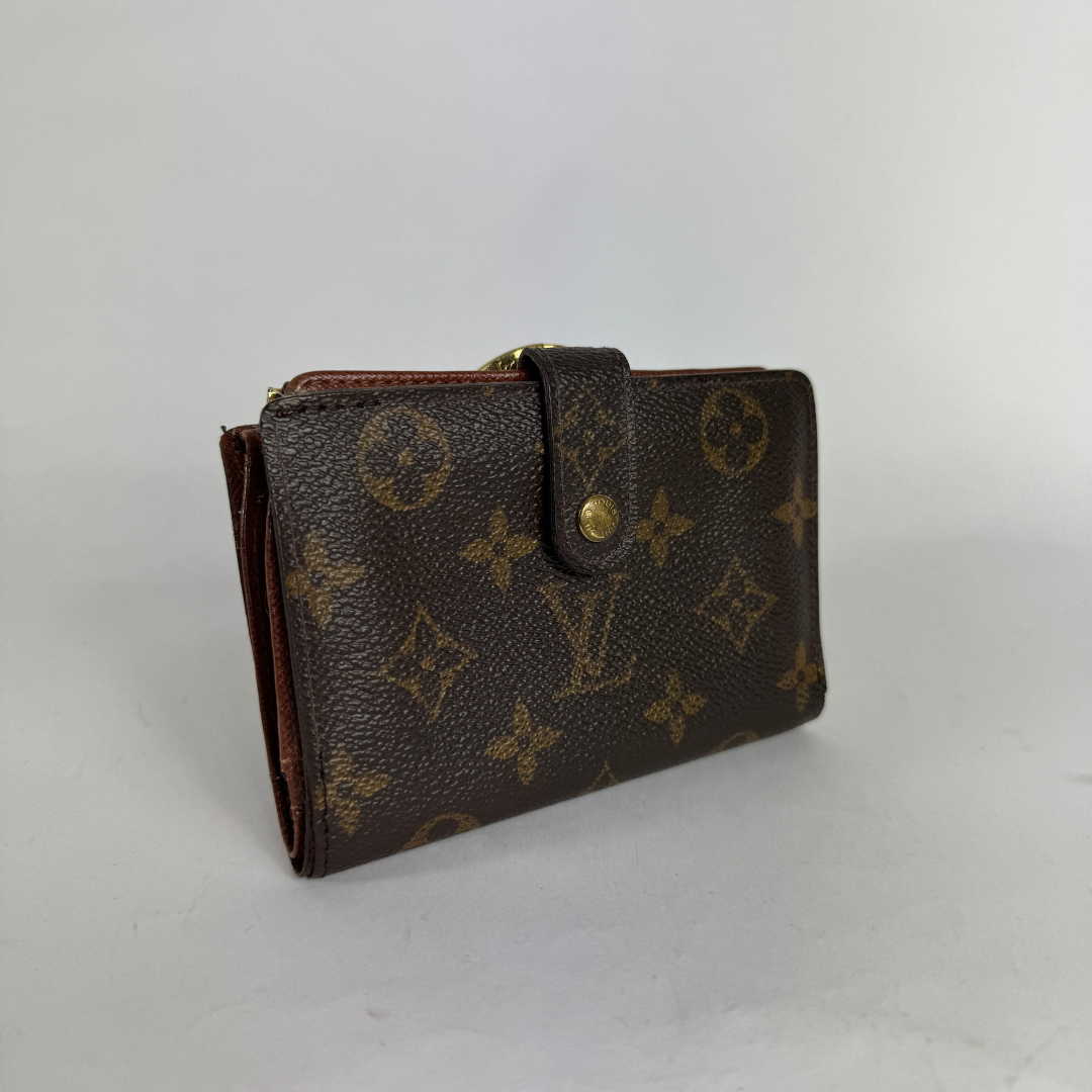 A Louis Vuitton monogram canvas wallet in dark brown with gold-toned hardware, photographed on a plain light gray background.