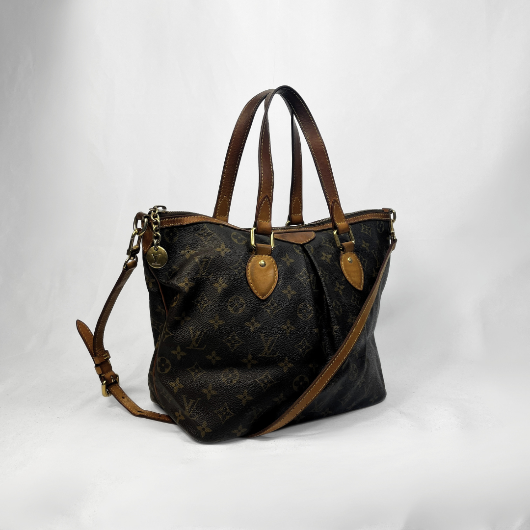 A Louis Vuitton monogram canvas tote bag with brown leather handles and shoulder strap, displayed on a white studio background.