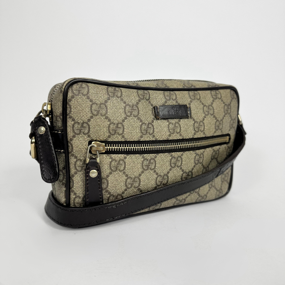 Gucci handbag with monogram pattern on a light gray background