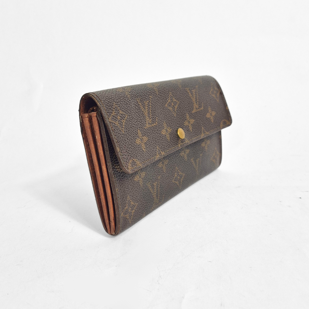 Louis Vuitton wallet with monogram pattern on a white background