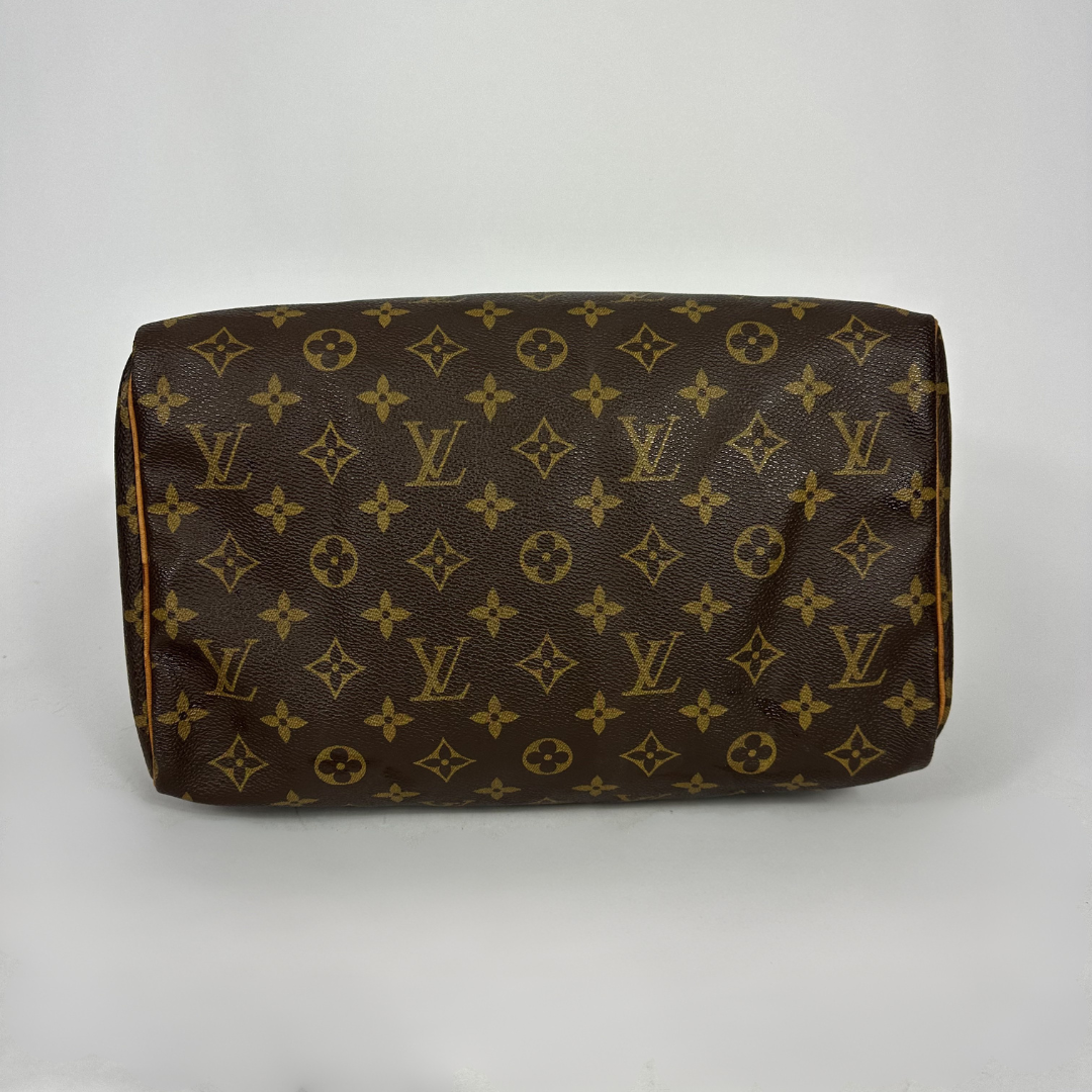 A Louis Vuitton monogram canvas shoulder bag in brown and tan, photographed against a neutral light gray background.