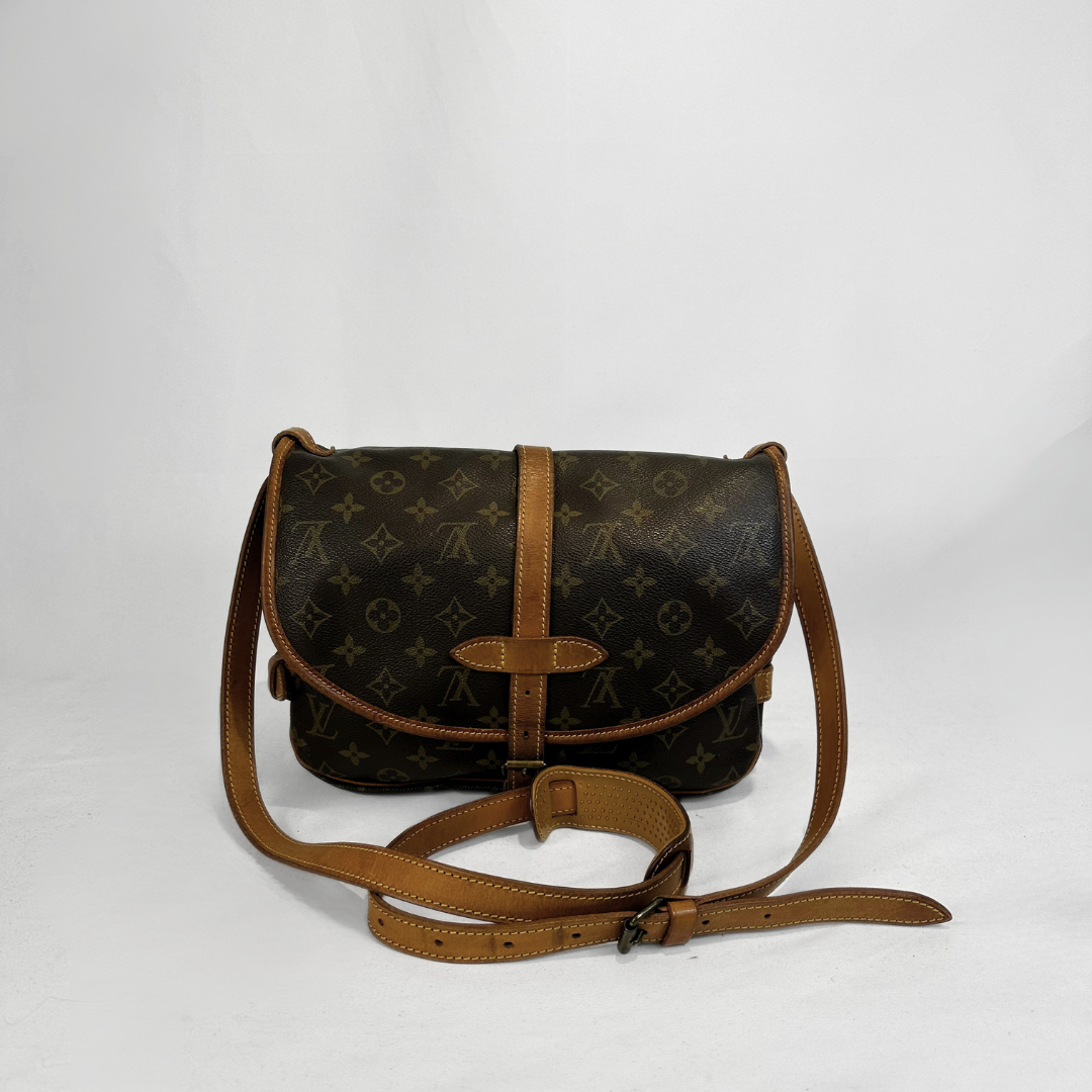 A Louis Vuitton monogram canvas shoulder bag in dark brown with tan leather trim and strap, displayed against a light gray background.