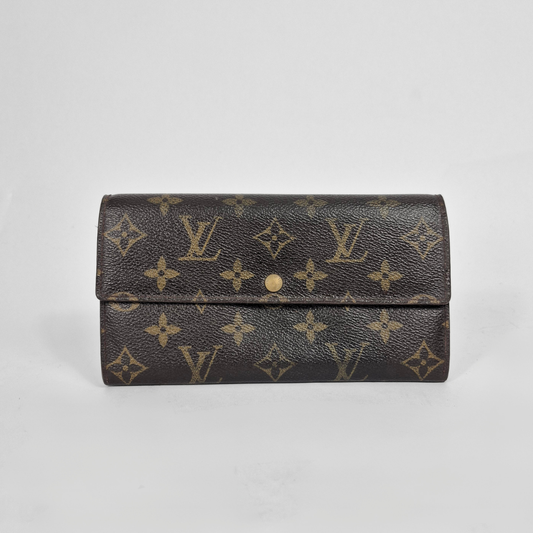 Louis Vuitton wallet with monogram pattern on a light gray background