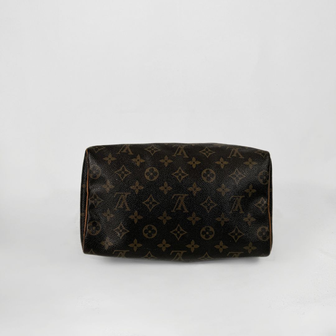 A Louis Vuitton monogram canvas toiletry bag in dark brown with tan monogram motifs, photographed against a plain white background.