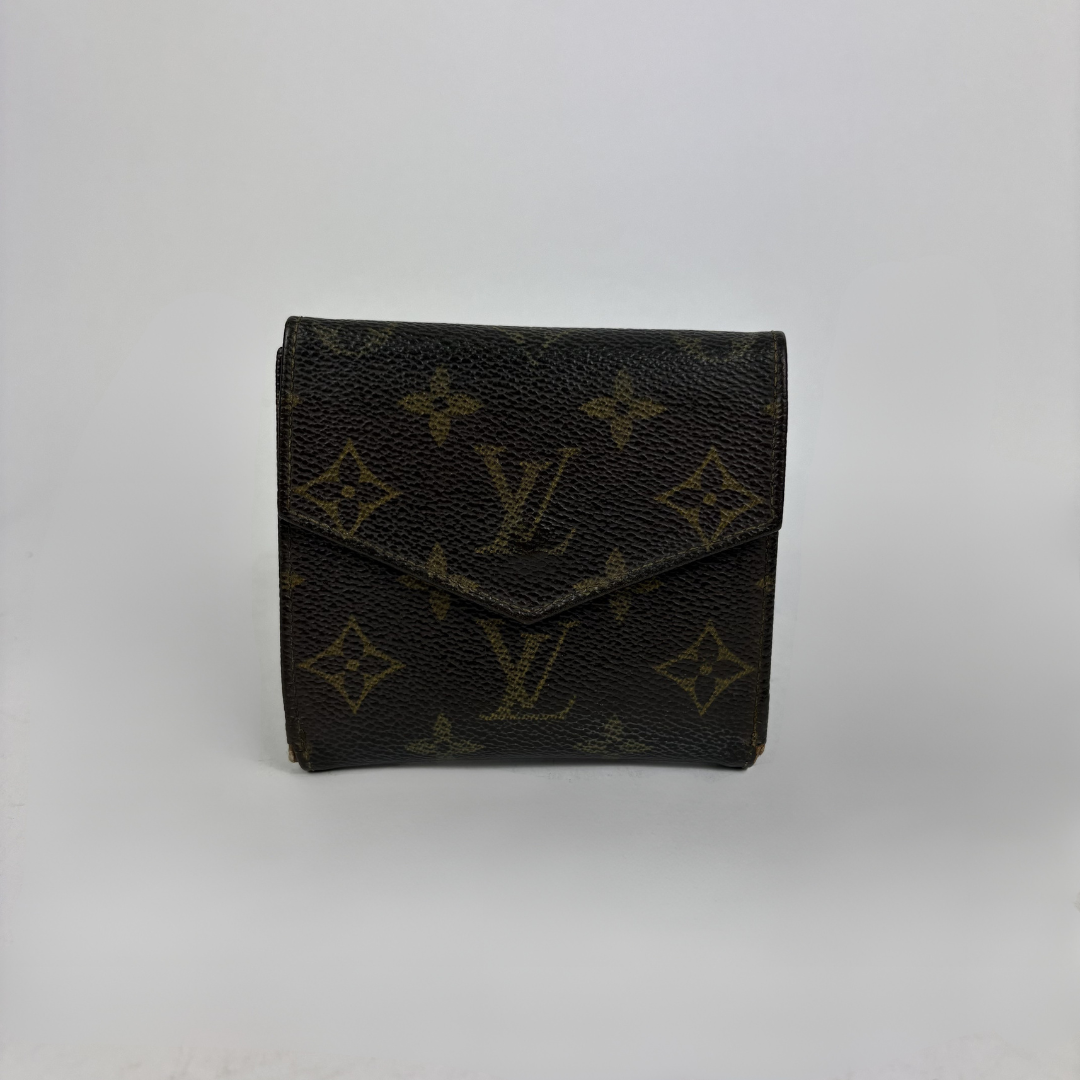 A Louis Vuitton monogram wallet in dark brown coated canvas with the classic tan/gold LV logo and floral motifs, photographed against a neutral light gray background.