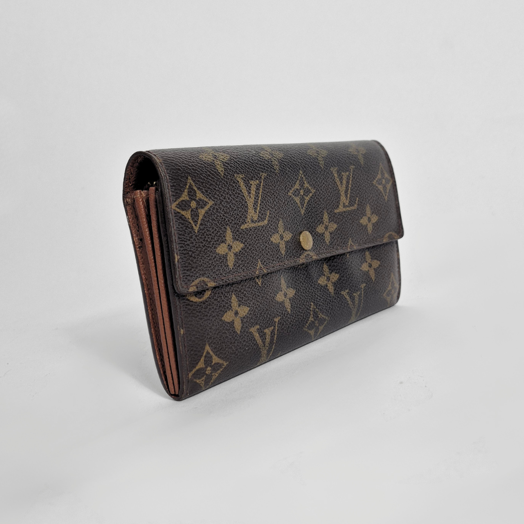 Louis Vuitton wallet with monogram pattern on a light gray background