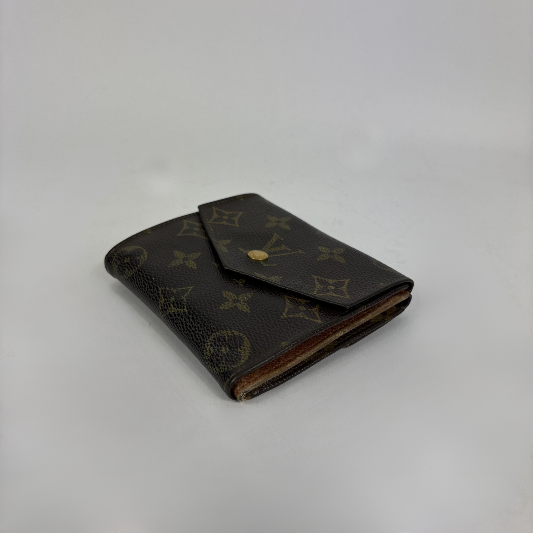 A classic Louis Vuitton monogram bifold wallet in dark brown coated canvas with gold-tone hardware, photographed on a neutral light gray background.