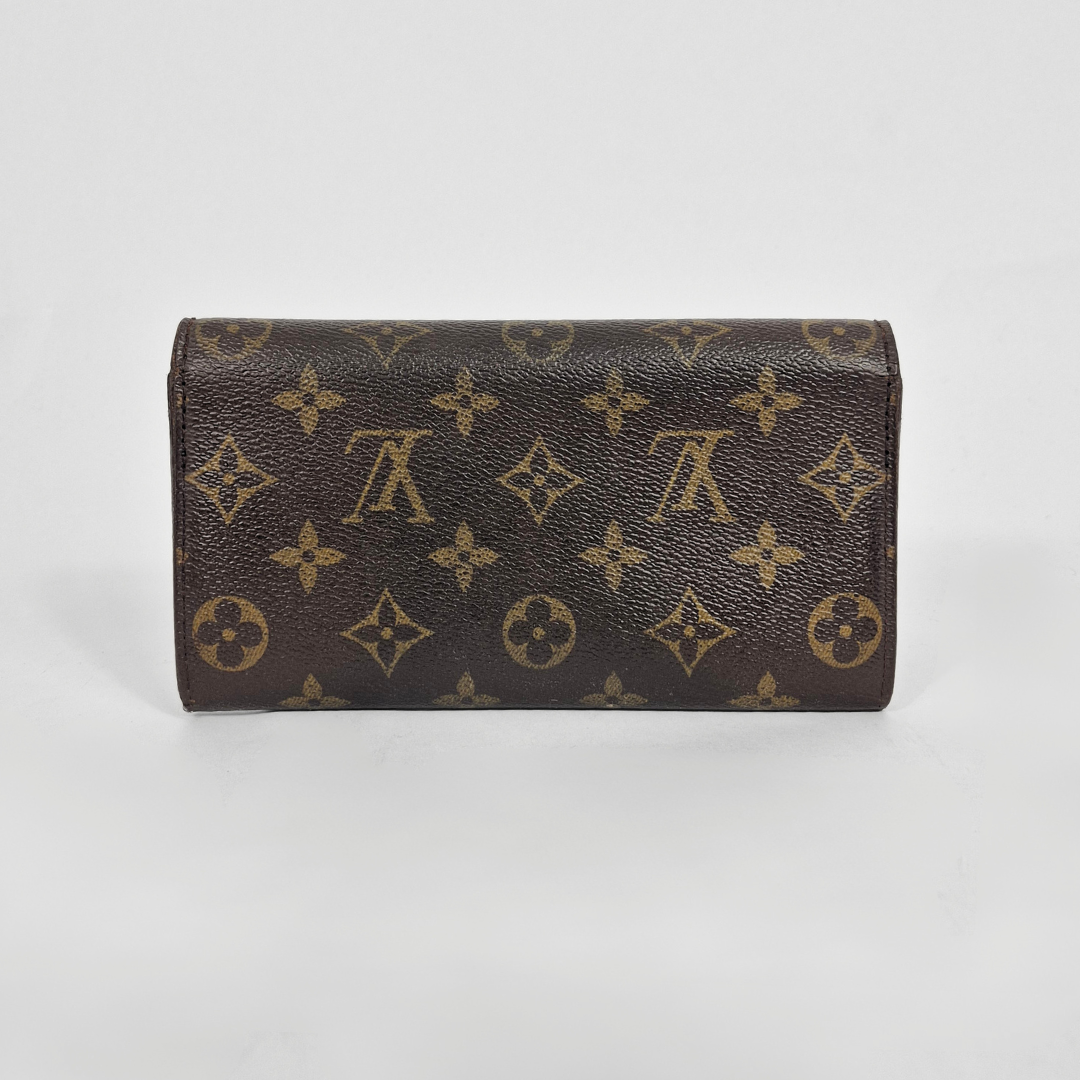 Brown wallet with monogram pattern on a light gray background