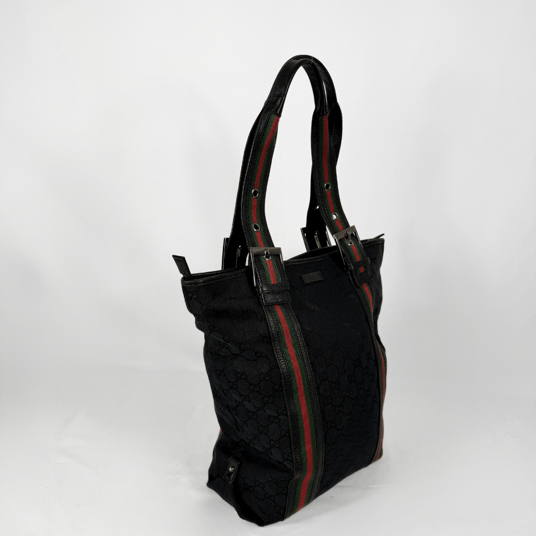 Gucci Canvas Web Joy Large Tote bag featuring the signature Gucci Web stripe detailing, displayed on a light grey background.