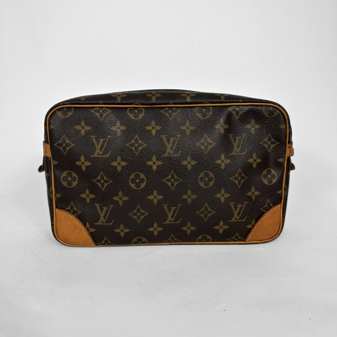 A Louis Vuitton monogram canvas toiletry bag in dark brown with tan leather corner protectors and trim, photographed against a light gray background.