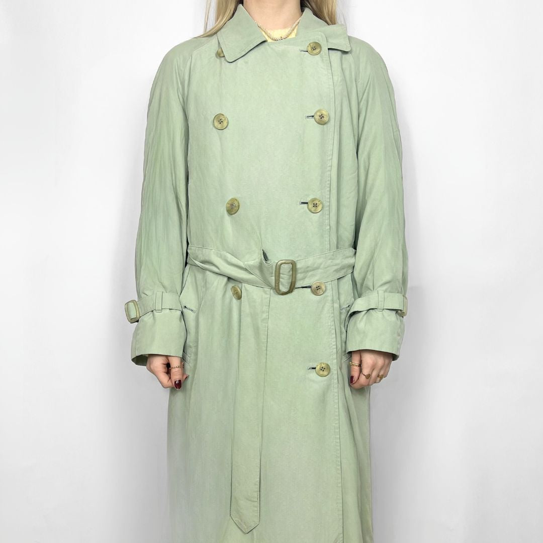 Light green trench coat with gold buttons on a white background