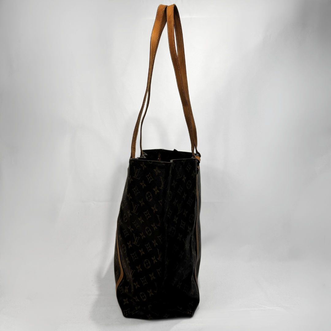 A Louis Vuitton monogram canvas tote bag with tan leather shoulder straps, photographed against a white studio background.