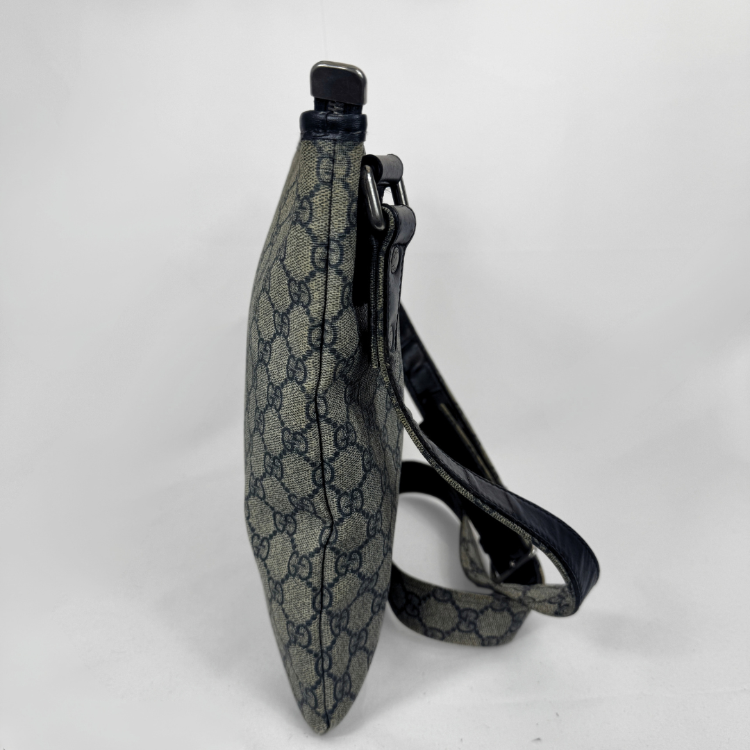 Gucci GG Supreme Web Flat Messenger bag in signature monogram canvas with green and red Web detailing and leather trims, displayed on a light grey background.