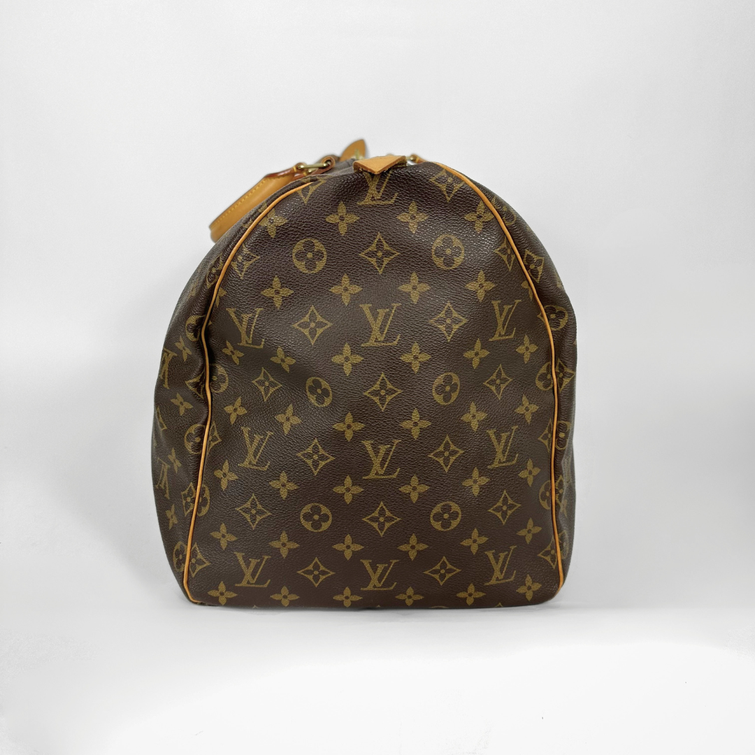 Louis Vuitton monogram duffel bag with tan handles on a white background