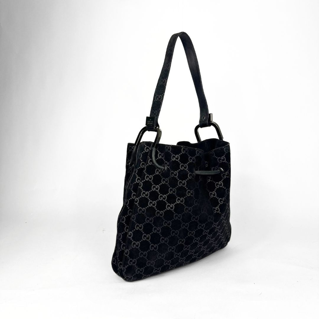 Gucci GG black suede shoulder bag on a white background