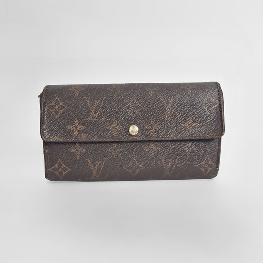 Brown wallet with monogram pattern on a light gray background