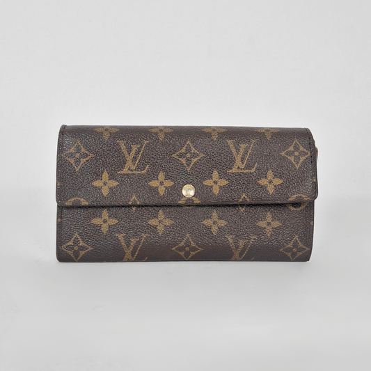 Louis Vuitton wallet with monogram pattern on a light gray background
