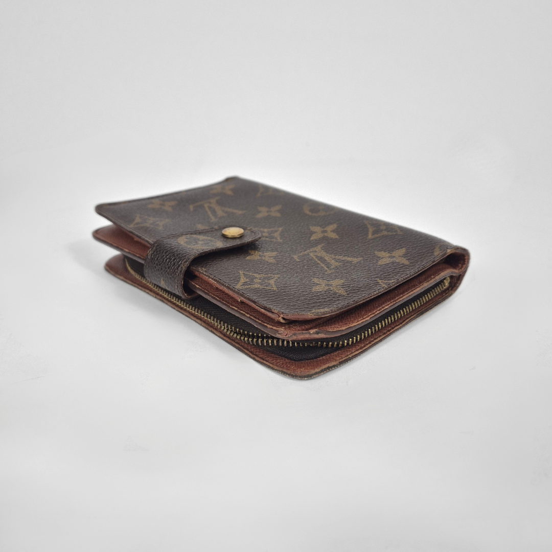 Louis Vuitton wallet with monogram pattern on a light gray background