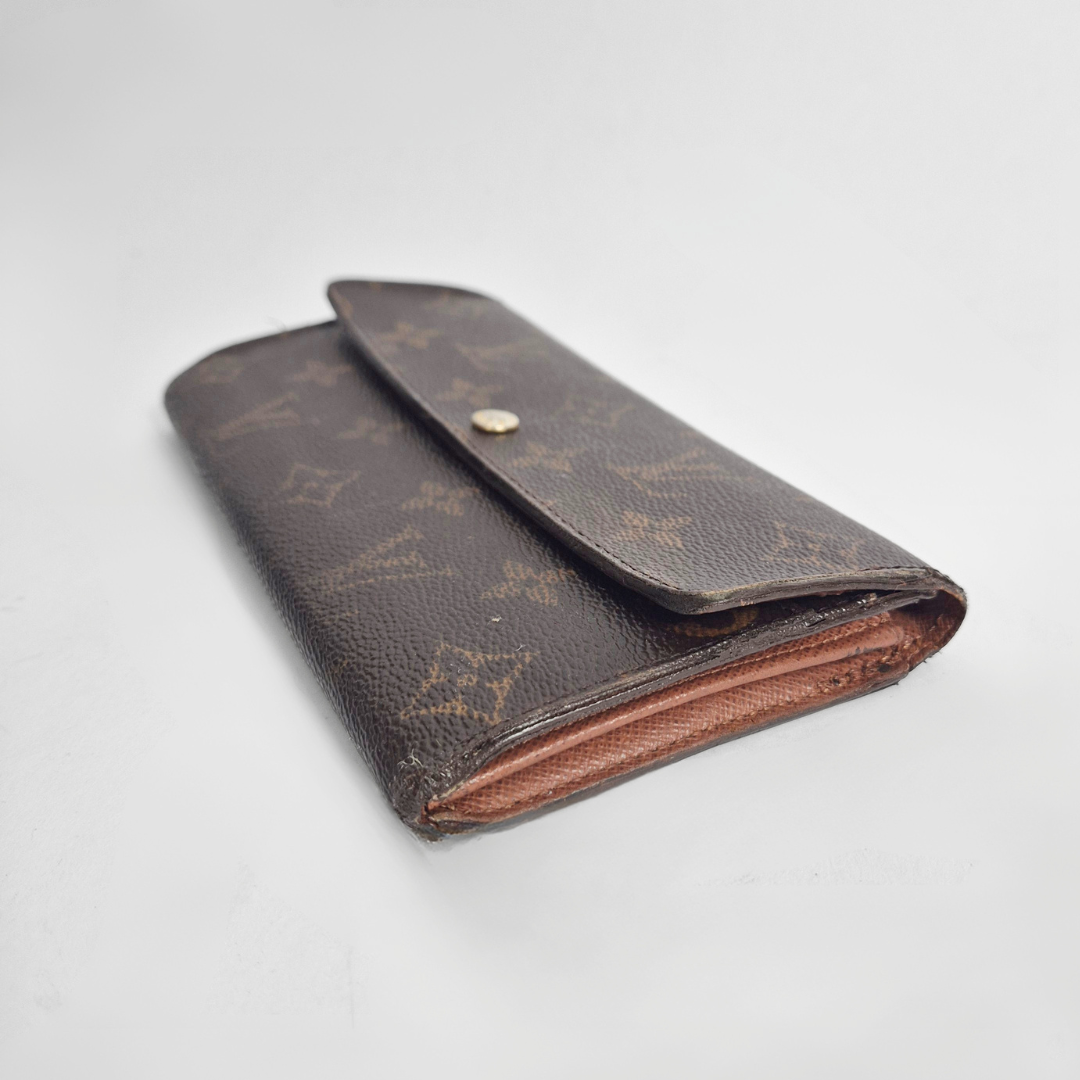 Vintage Louis Vuitton wallet with monogram pattern on a light gray background