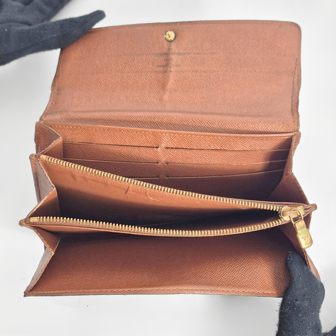 Brown leather wallet with gold zipper on a white background