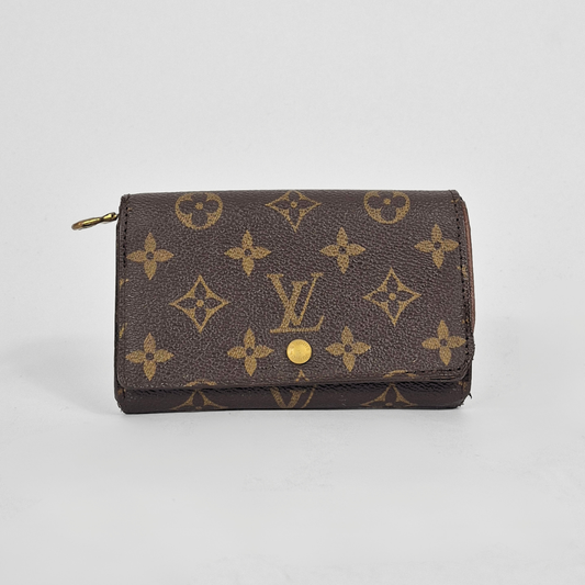 Louis Vuitton wallet with monogram pattern on a light gray background