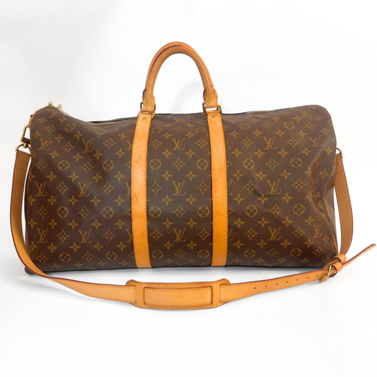 Louis Vuitton monogram duffel bag with tan leather straps on a white background