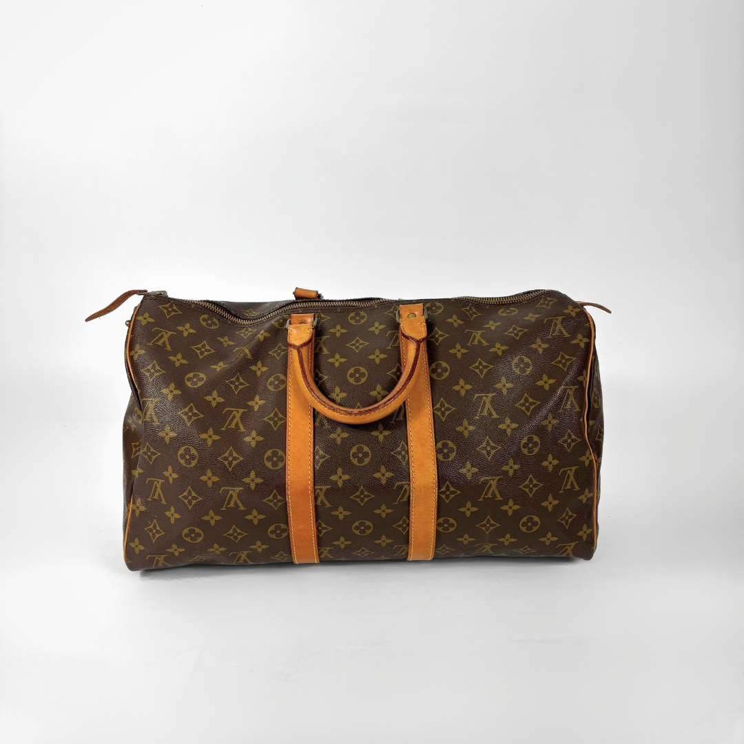 Brown monogram duffel bag with tan handles on a white background