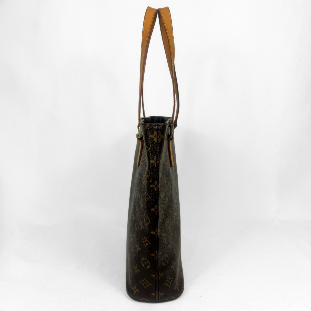 Louis Vuitton monogram canvas bag with tan leather shoulder straps, shown from the side against a white studio background.