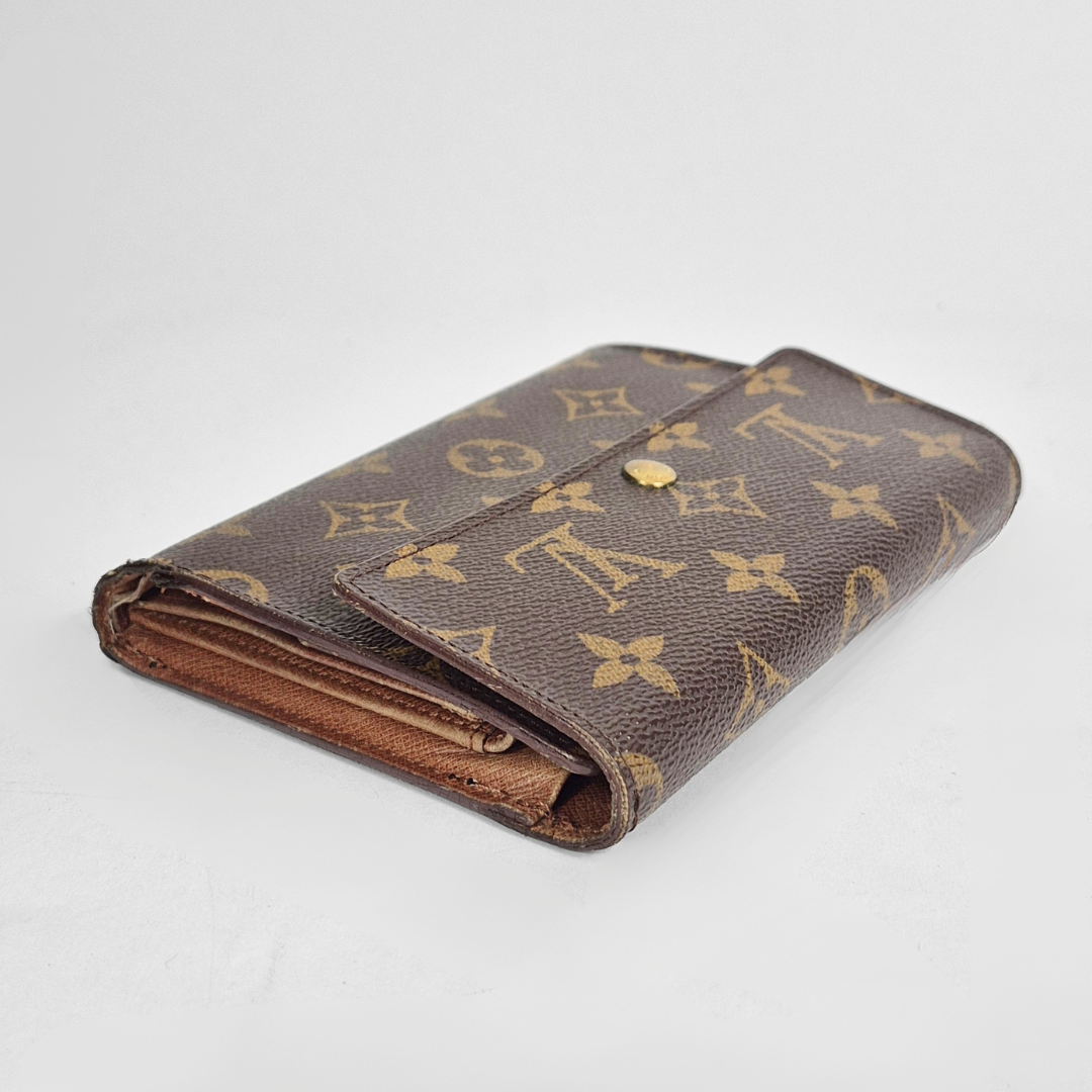 Louis Vuitton wallet with monogram pattern on a white background