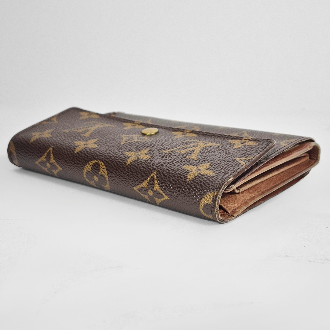 Louis Vuitton wallet with monogram pattern on a white background
