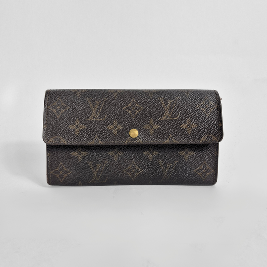 Designer wallet with monogram pattern on a light gray background