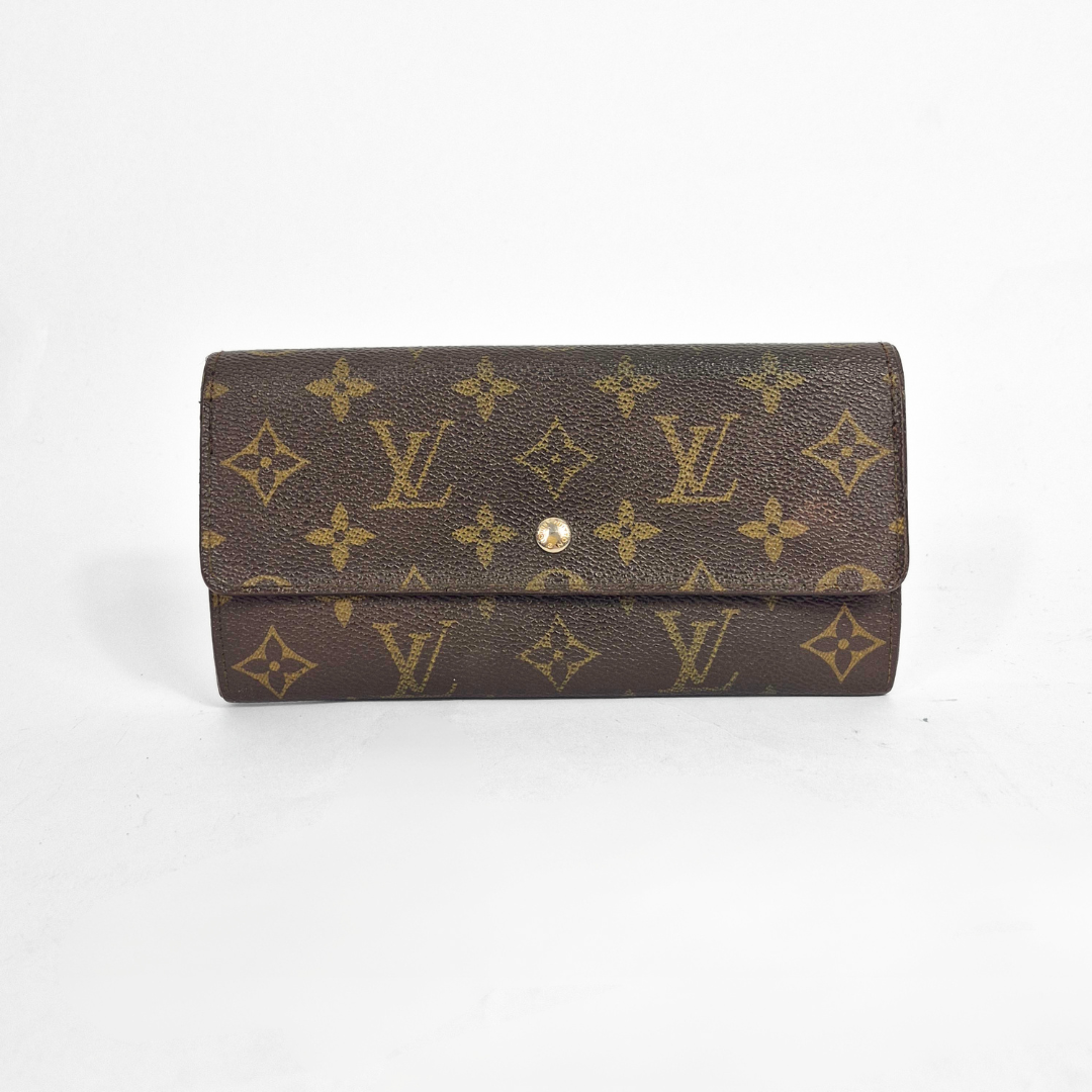 Brown wallet with gold monogram pattern on a white background