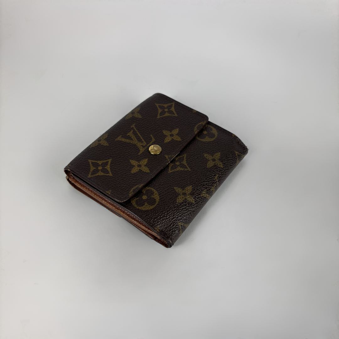 A brown monogram wallet with a gold snap button closure, photographed on a light gray background.