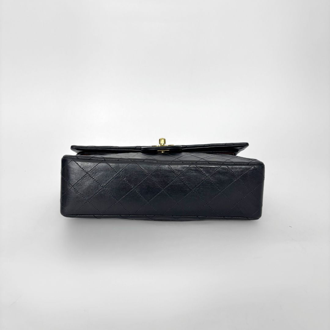 Black quilted handbag on a light gray background
