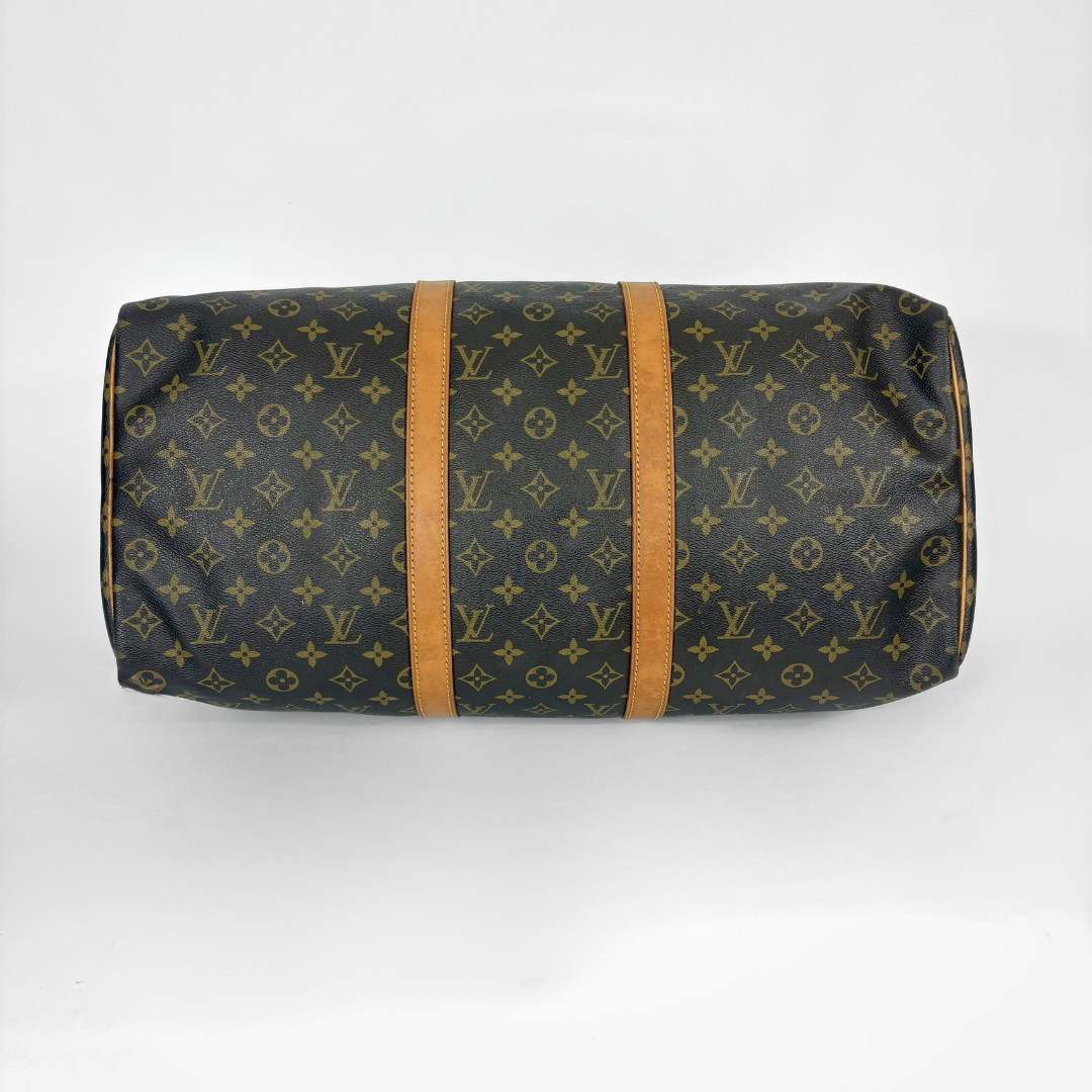 Louis Vuitton monogram duffel bag with brown straps on a white background