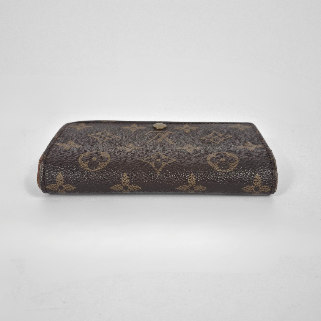 Louis Vuitton wallet with monogram pattern on a white background