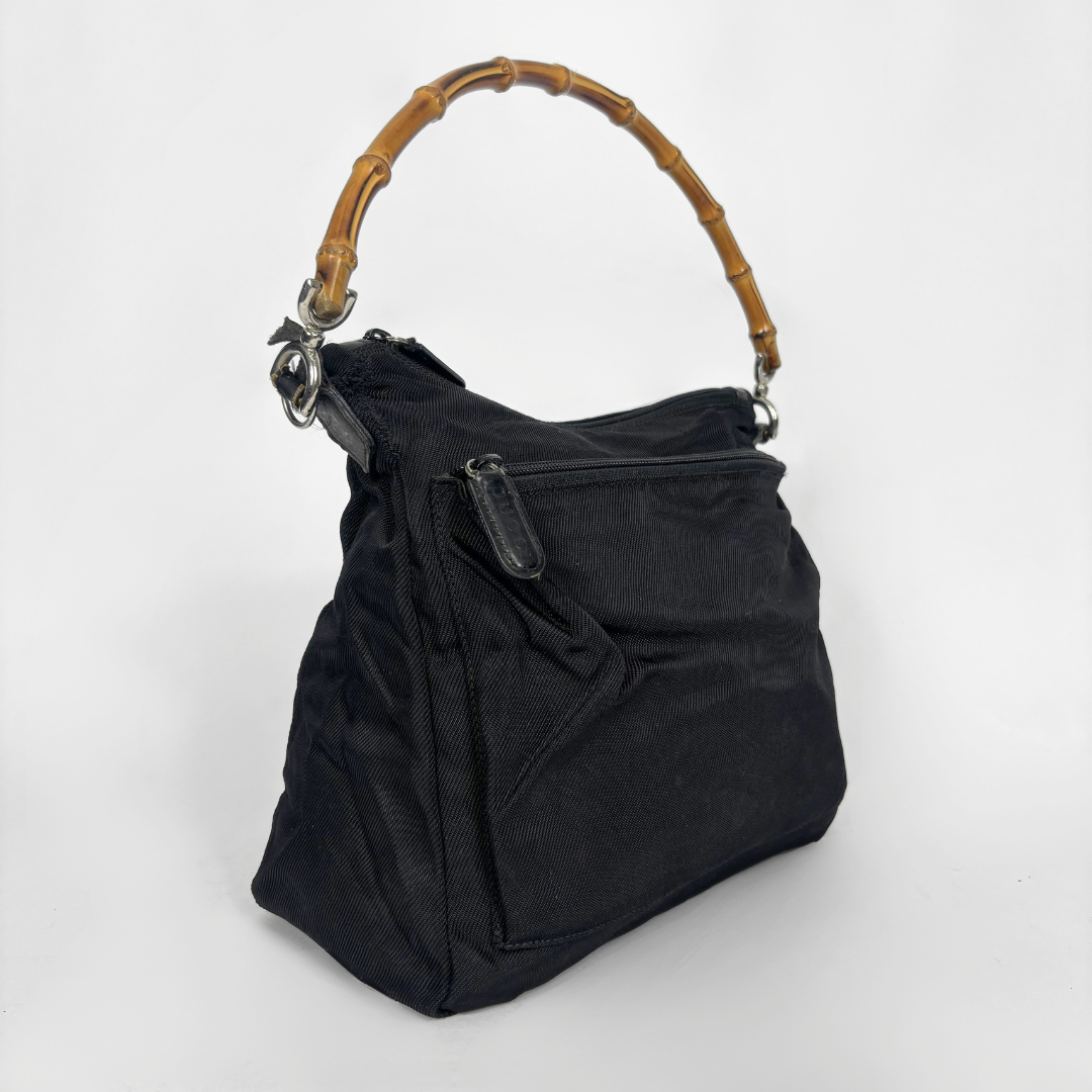 Black handbag with a bamboo handle on a white background