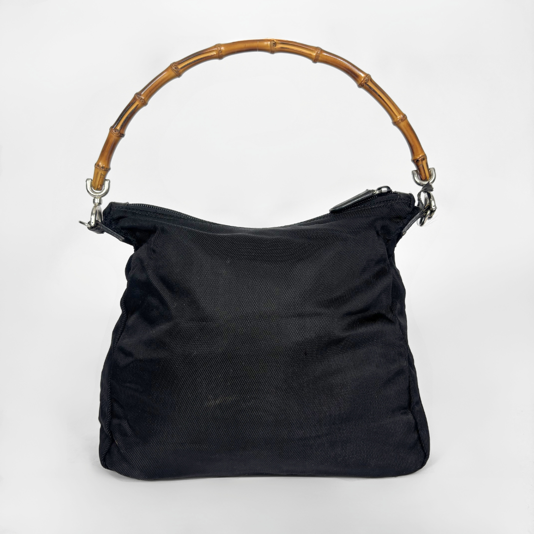 Black handbag with a bamboo handle on a white background