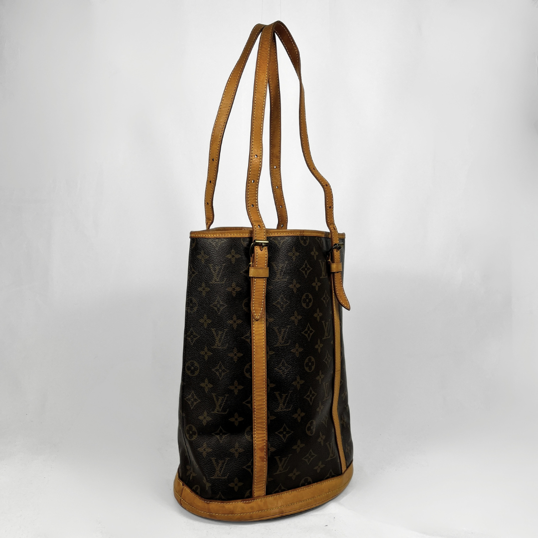 A Louis Vuitton monogram canvas bucket tote bag with tan leather trim and shoulder straps, shown against a plain white background.