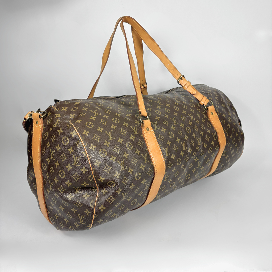 Louis Vuitton duffel bag with monogram pattern on a light gray background