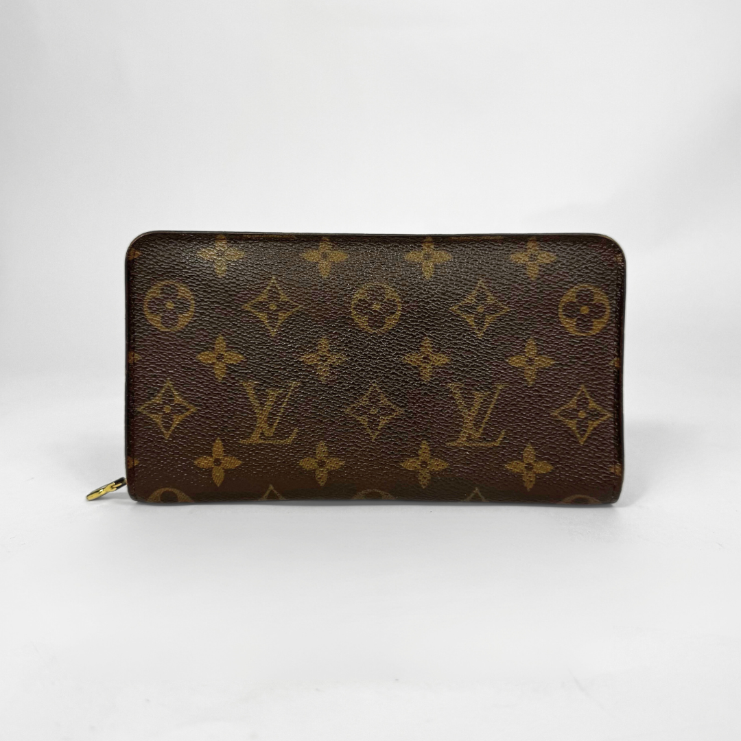 Louis Vuitton wallet with monogram pattern on a white background