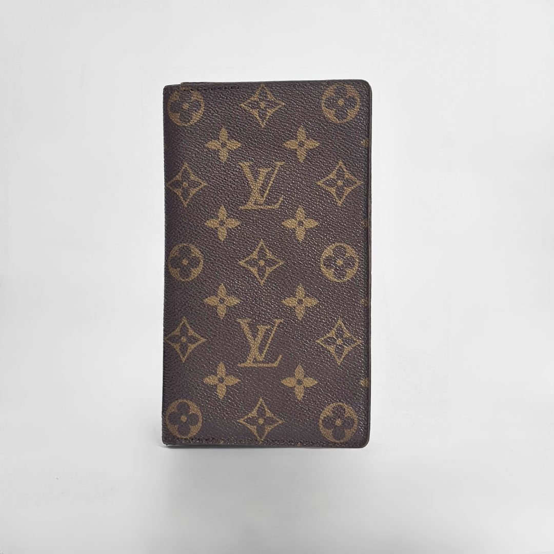 Louis Vuitton wallet with monogram pattern on a light gray background
