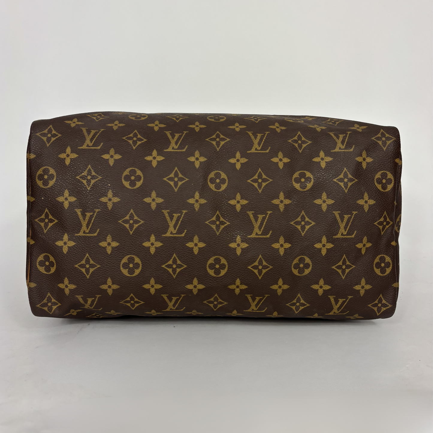 Brown leather bag with gold monogram pattern on a white background