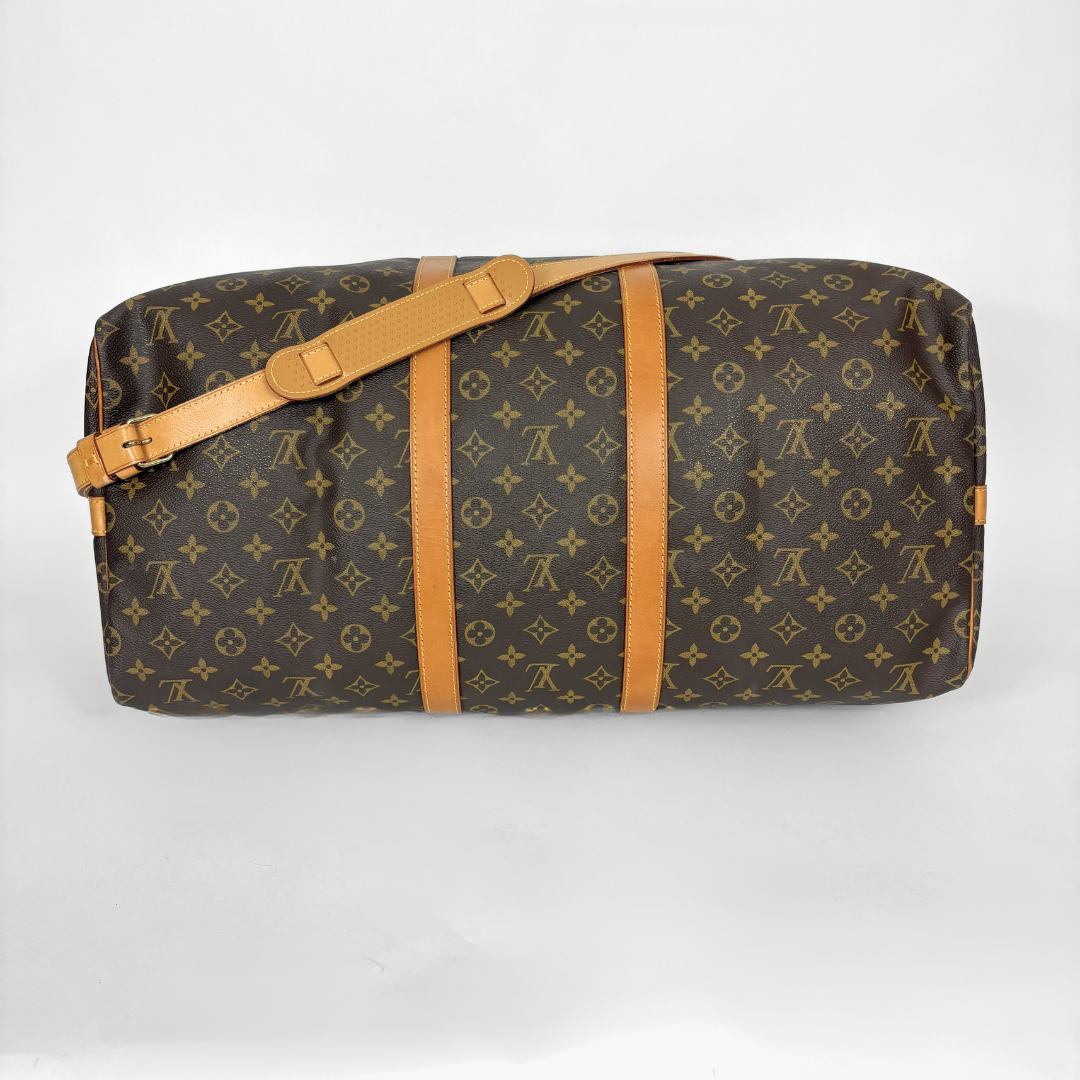 Brown monogram duffel bag with tan leather straps on a white background
